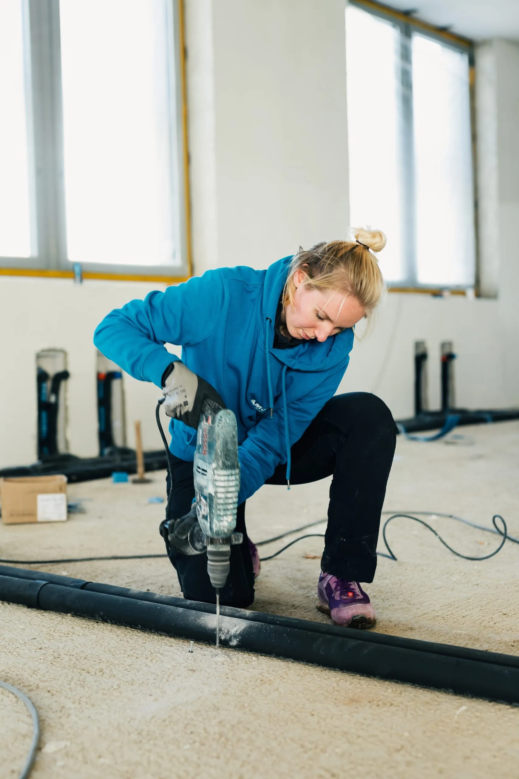 SHK-Fachhandwerkerin Antonella Menrath befestigt ein Heizungsrohr