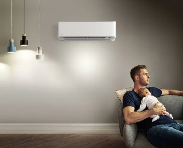 Milieubild Panasonic Raumklimager&auml;t und junger Vater mit Baby davor sitzend.