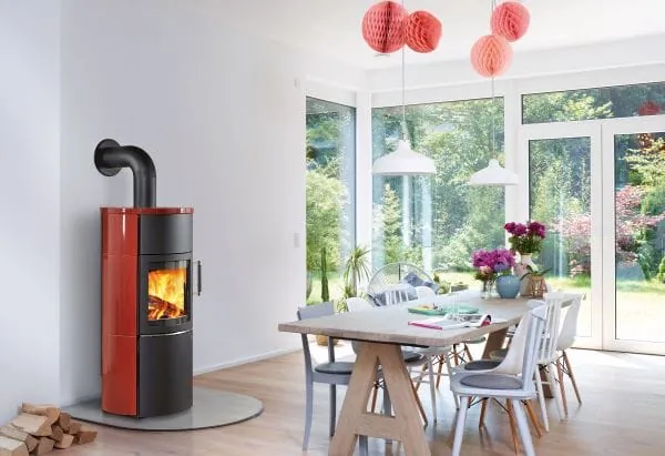 Milieufoto moderner Holzofen im Essraum mit bodentiefen Fenstern.