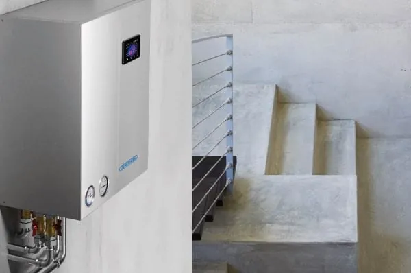 W&auml;rmepumpen-Hydraulikstation an der Wand im Geb&auml;udeinneren.