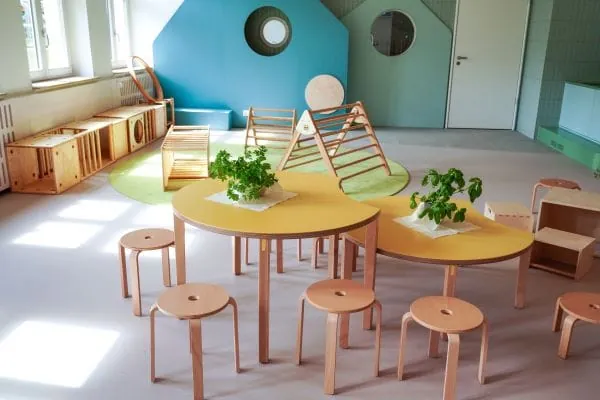 Heller Raum mit Stuhlgruppe und Holz als zentralem Gestaltungselement.