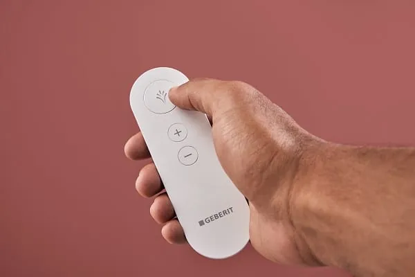 Mit der Fernbedienung lässt sich der Duschvorgang des AquaClean Alba starten und die Duschstrahlstärke regulieren.