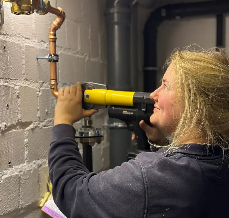 Melissa Stadali bei der Verlegung einer neuen Gasleitung mit Pressverbindung von Kupferrohr.