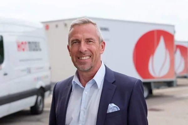 Portr&auml;tfoto Hotmobil-Gesch&auml;fstf&uuml;hrer Bernd Becherer vor Fuhrpark