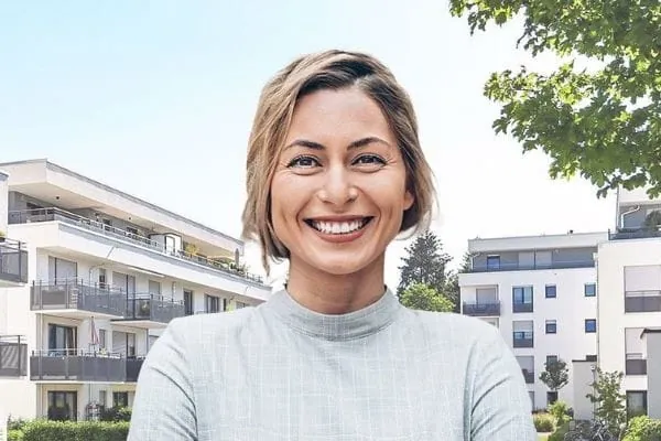 Lachende Frau vor Wohngebäuden