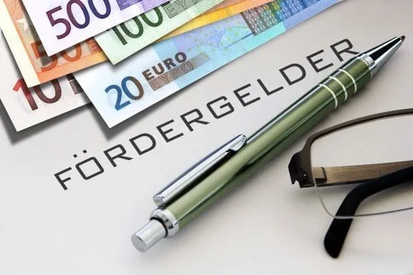 Geldscheine, Schriftzug Fördergelder, Kugelschreiber und Brille