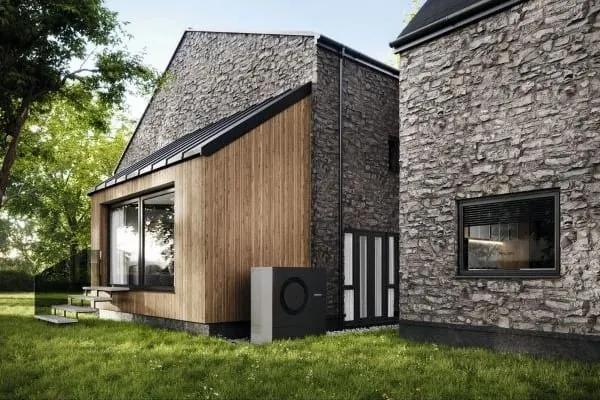 Grafik Einfamilienhaus mit Natursteinfassade. Davor eine schwarze Buderus- Luft-/Wasser-Wärmepumpe