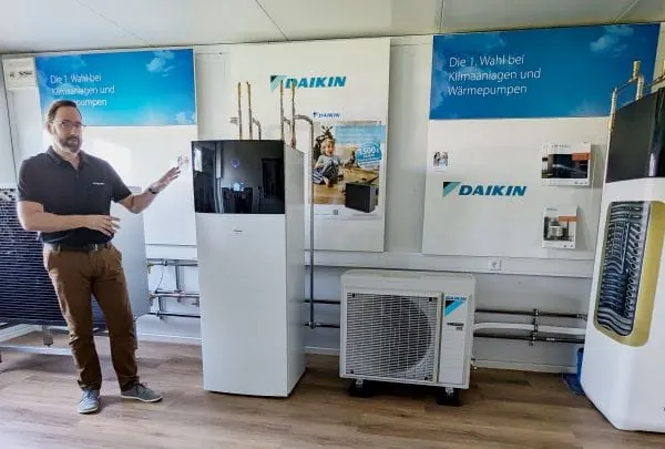 Schulungsleiter bei Reisser steht neben Wärmepumpen von Daikin, Innen- und Außengerät.