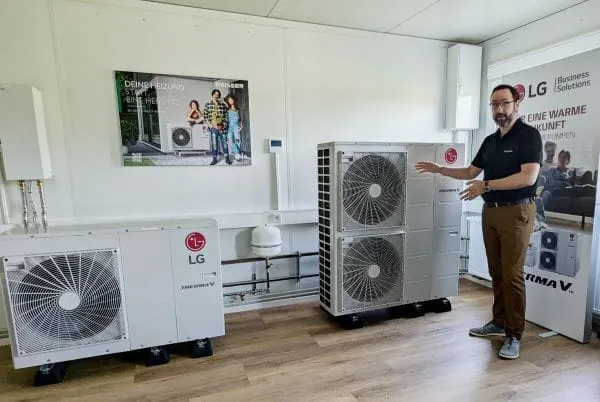 Schulungsleiter beim Großhändler Reisser steht vor zwei unterschiedlichen LG-Wärmepumpen