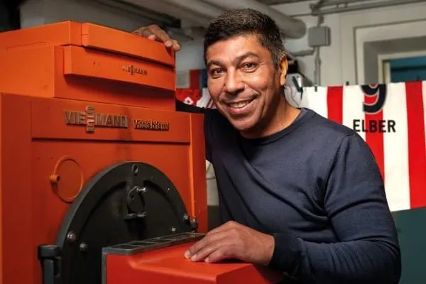 Fu&szlig;ball-Legende Giovane &Eacute;lber vor altem , orangen Viessmann-Heizkessel