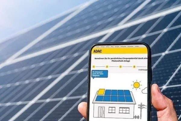 Handy-Display mit Anzeige Solar-Förder-Ranking 80 deutscher Großstädten vom ADAC. Im Hintergrund PV-Module