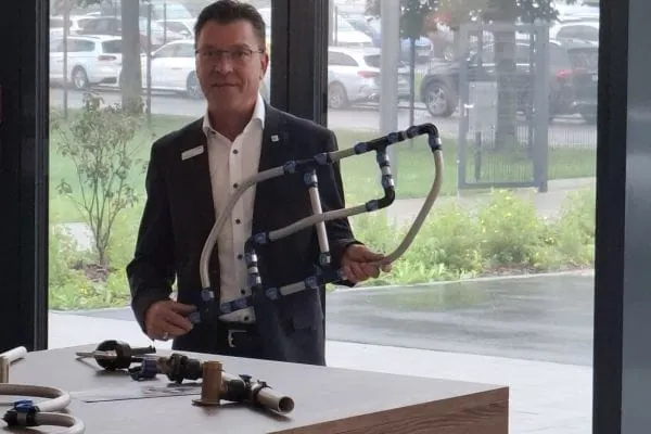 Geberit-Schulungsmitarbeiter mit Rohrstück zum Lernen von PE-Schweißen