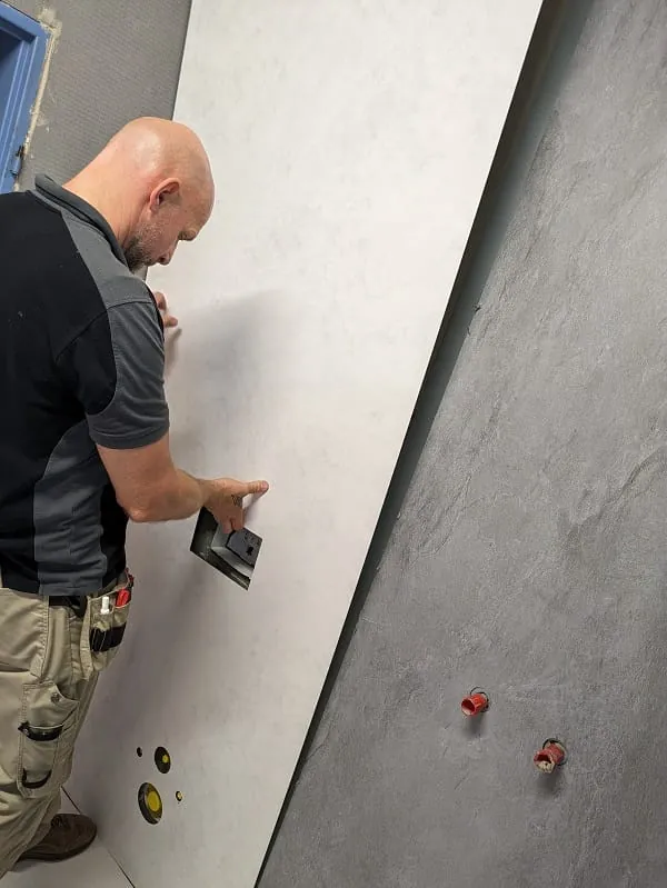 Auch die zweite Platte kann einfach per Hand an die Wand gebracht werden. Schon jetzt zeigt sich, dass die farblich abgesetzten Vipanel-Beton-Optiken das betagte Bad zum neuen Hingucker machen werden.