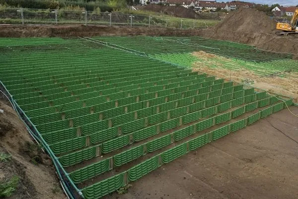Große Erdkollektoranlage mit dunkelgrünen, vertikalen Kollektoren vor der Überdeckung mit Erde.