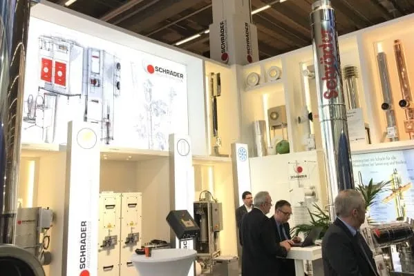 Messestand Schr&auml;der mit Abgastechnik, Feinstaubfiltern. Abgasw&auml;rmetauschern und einigen Messebesuchern