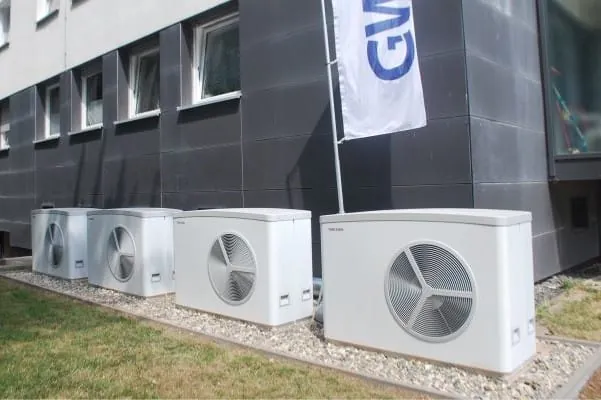 Vier W&auml;rmepumpen vor Mehrfamilienwohnhaus