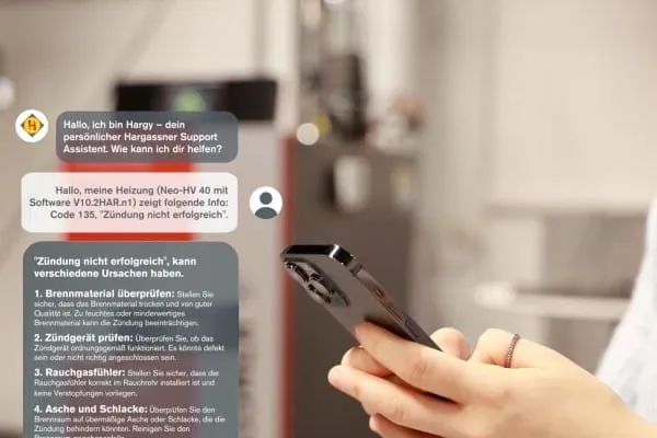 Frauenhand Handy tippend, auf linker Seite im Bild erscheint eingegebener Text in die Hargy-App