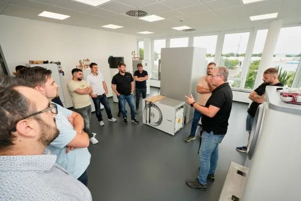 8 SHK-Handwerker und ein Schulungsleiter im Schulungsraum "Wärmepumpe" bei Bosch.