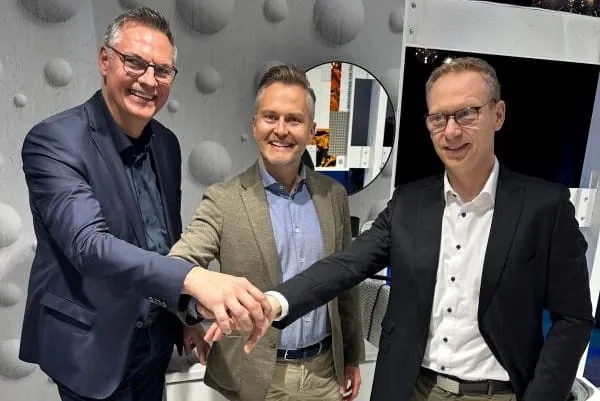 Drei Männer in Anzügen geben sich die Hand. Im Hintergrund Badausstellung Großhandel.