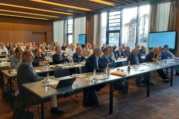 Konferenzteilnehmer sitzen an Tischen.