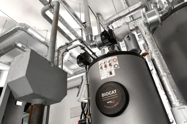 Biocat-Kalkschutzanlagen im Heizungskeller mit Verrohrung im Hintergrund.
