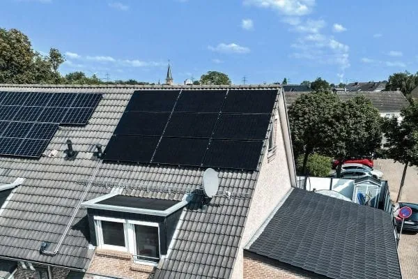 Reihenhaus mit Spitzdach. Darauf PVT-Module.