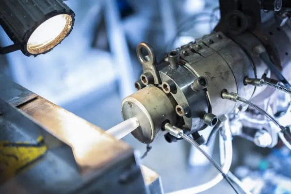 In der Rohrfertigung wird mithilfe eines Extruders Kunststoffgranulat aufgeschmolzen. Am Austritt des Extruders wird durch ein formgebendes Werkzeug die Schmelze in Rohrform gebracht. In einer Kalibrier-einrichtung wird das Rohr auf die finale Geometrie gebracht, im Anschluss wird das Rohr gekühlt und auf die gewünschten Längen konfektioniert.