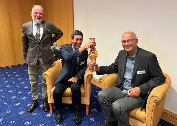 Lachender Martin Bentele stehen neben den auf Sesseln sitzenden Volker Lenz und Christian Rakos. Sie halten ihre Pellet-B&auml;ren &uuml;bereinander. Freudige Stimmung