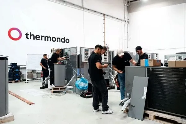 Schulungszentrum innen mit W&auml;rmepumpen und Elektrikerns, die daran lernen