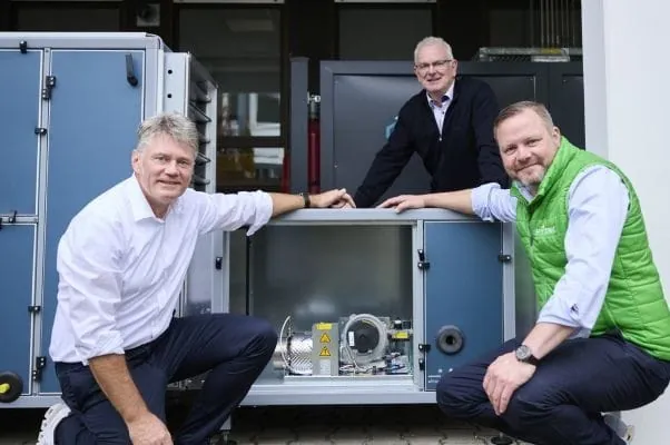 Drei Ingenieure gruppiert um das Wasserstoff-Luftheizsystem von Hyting