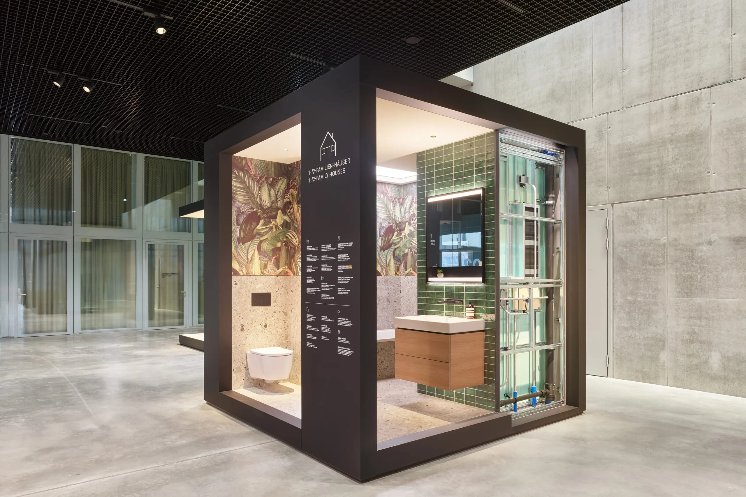 Ein zentraler Bestandteil sind die anwendungsorientierten Bauaufgaben. Begehbare Kuben zeigen reale Badsituationen – mit sichtbarer Installation auf der Rückseite