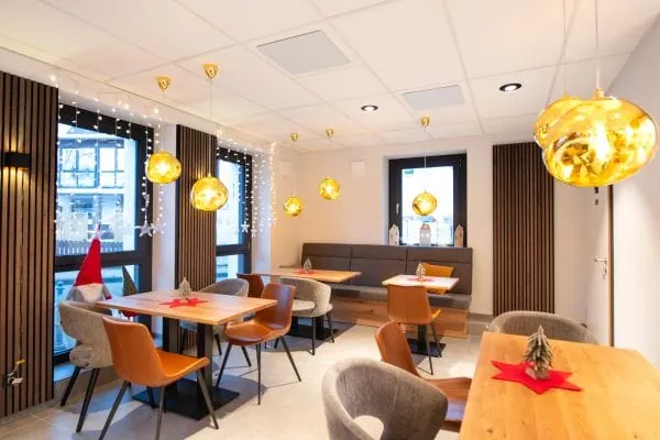 Sanierungsprojekt von Fries Architekten: An der Decke montierte Infrarotheizungen in dem Caf&eacute; im umgebauten Westerw&auml;lder Hof