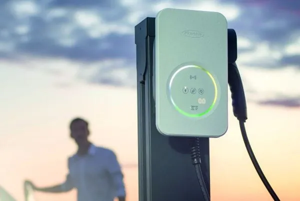 Ladestation Wattpilot, im Hintergrund E-Auto-Fahrer der Autot&uuml;r zumacht