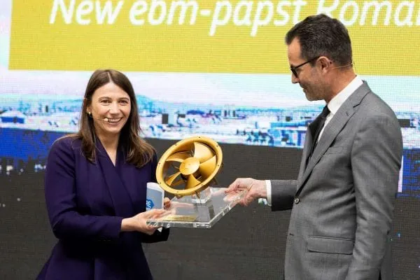 Frank Mayer, COO ebm-papst Gruppe & CEO Air Technology Europe, &uuml;berreicht Delia Ungur, Gesch&auml;ftsf&uuml;hrerin von ebm-papst Rum&auml;nien, eine goldene Version des ersten Ventilators, der im neuen Standort produziert wurde.