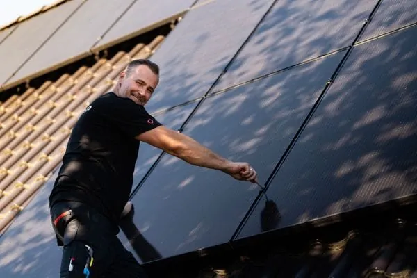 PV-Installateur auf dem Dach bei Montage der Module