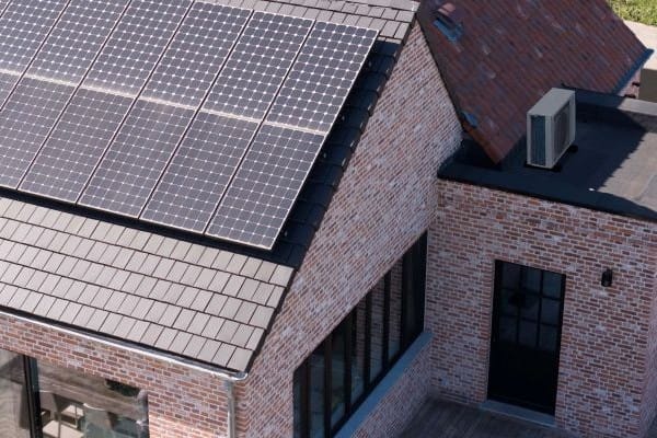 PV-Dach und Luft-Klima-Splitgerät auf dem Flachdach daneben