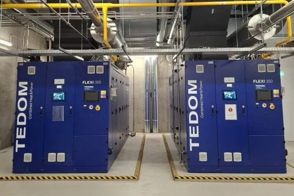 zwei dunkelblaue BHKW nebeneinander in einer Energiezentrale mit Rohrsystem